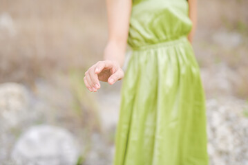Gentle woman's hands with neutral manicure isolated on nature background