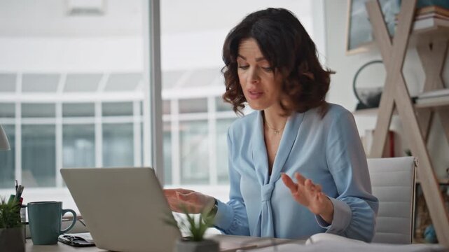 Businesswoman conducting video meeting by laptop at workplace office closeup.