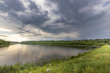 A lake with a cloudy sky in the background