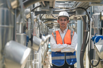 Engineers inspect gas and water pipes for power and cooling in industrial and building systems. workers in safety gear work seriously in oil and gas refining plant with pipes connecting to machinery.