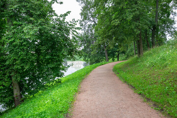 A path in a park with trees and a body of water
