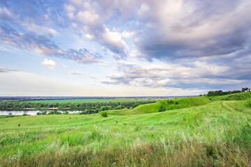 Obraz premium A large field of grass with a river in the background