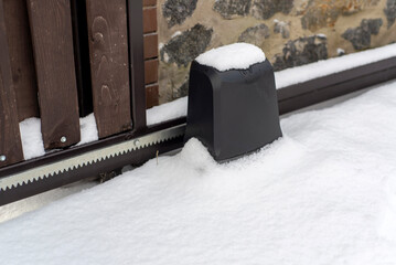 Sliding gate on a fence in the snow in winter.