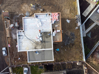 Roofing construction worker installing a flat roof. Bright blue sky in the background.