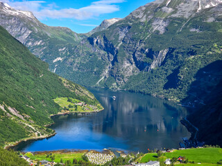 Serene Fjord Reflection Near Geiranger, Norway Under Clear Blue Skies