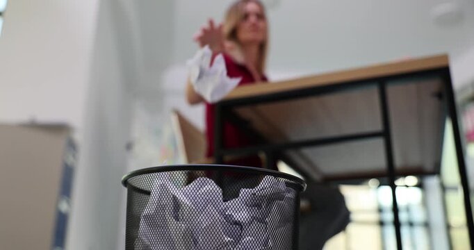 Frustration at work and crumpled paper in trash