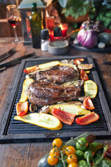 two steaks of meat and vegetables grilled on the grill table
