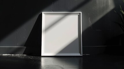 A minimalist white frame stands against a black wall, illuminated by contrasting shadows, creating a serene and artistic atmosphere