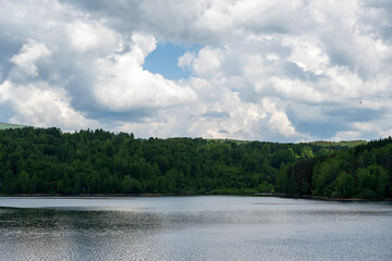 White puffy clouds and blue sky above Vlasina Lake. White cumulus clouds and a blue sky with sun...