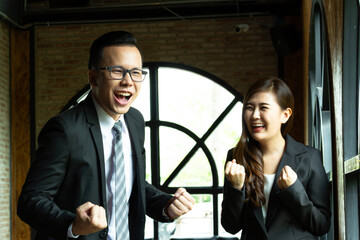 Young business couple working and discussing, business people working on project together in modern coffee shop background. Brainstorming at coffee break out of the office.