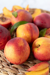 Fresh nectarine peaches with leaves on bamboo table. Eating ripe organic summer fruit.