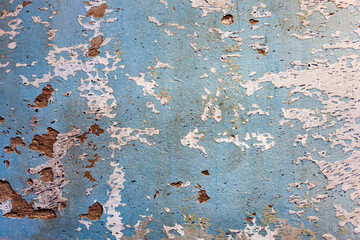 Textured wall surface with cracks and scratches. Peeling paint on a concrete wall. Close-up view.