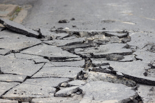 A cracked road with a lot of debris