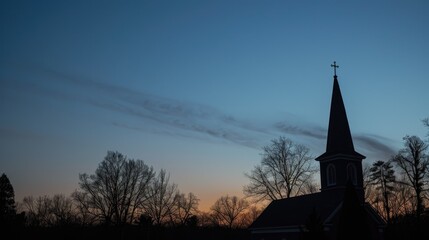 Obraz premium Peaceful evening scene with a church steeple silhouetted by the last light of the day.