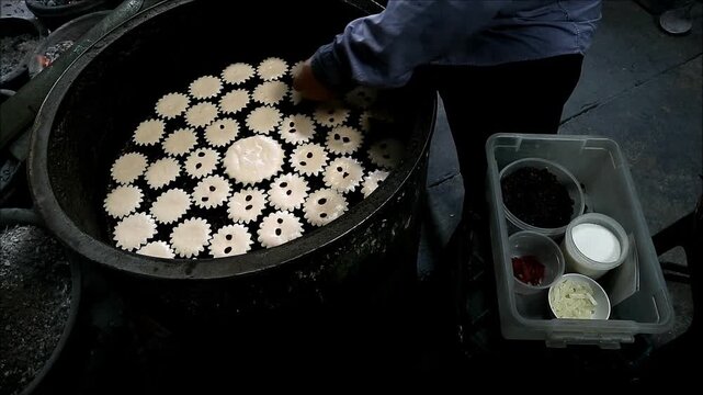Footage of Baker Adding Dried Fruits on the Mid-baked Batter of Khanom Farang Kudeejeen, a Famous Portuguese Influenced Cupcakes in Thailand