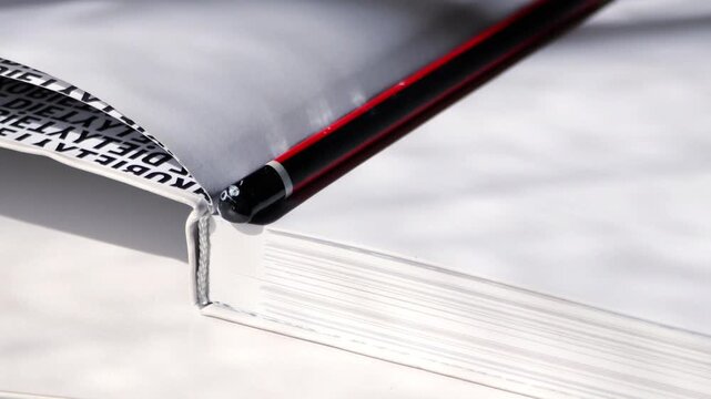 Red Pencil Resting on Open Book
A close-up video showcasing a red pencil resting on the pages of an open book. The scene highlights the themes of education, creativity, and literary insp