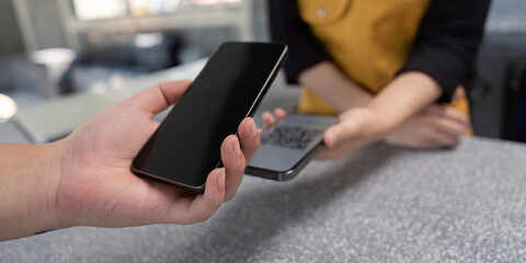 Close up of Hands Using Mobile Phones for Contactless Payment at a Modern Retail Counter