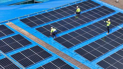 engineer man inspects construction of solar cell panel or photovoltaic cell by electronic device. Industrial Renewable energy of green power. factory worker working on tower roof.