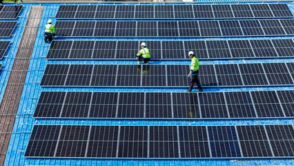 Worker Technicians are working to construct solar panels system on roof. Installing solar photovoltaic panel system. Men technicians walking on roof structure to check photovoltaic solar modules.