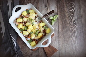 Italian dish, potato gnocchi with addition of herb pesto, cheese and mushrooms on cast iron frying pan