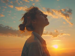 Silhouetted figure gazing with hopeful expression towards the glowing sunset horizon