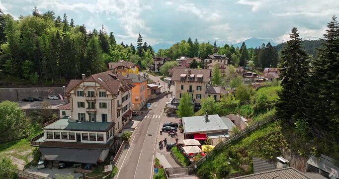 Aerial view Mendola Italy cityscape. Beautiful houses of an alpine village on a mountain slope in a forest in the Dolomite Alps. High quality 4k footage