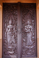 Wood carvings angel are made into gauge doors of temple at Wat Phra That Ket Kaew Chulamanee, Chaiyaphum, Thailand.Traditional Thai sculpture style.Vertical.
