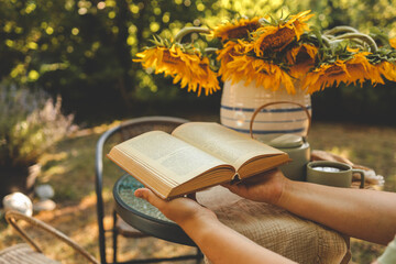 Girl reading a book in the garden, good summer morning concept
