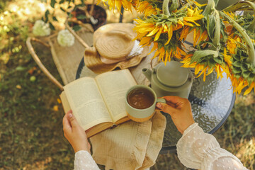 Girl reading a book in the garden, good summer morning concept