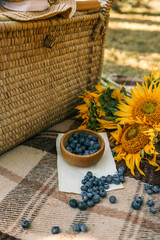 Picnic basket, book and sunflowers in the garden, summer mood