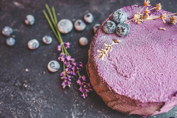 Cake with blueberries and lavender on a black background