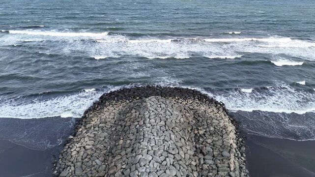 Aerial view of sea wall with breaking waves in Cilacap, Indonesia