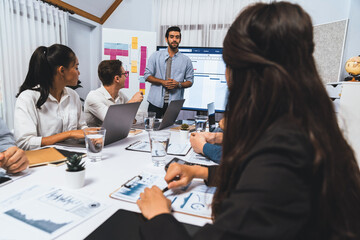 Fototapeta premium Project manager communicate and collaborate with team using project management software display on monitor, tracking progress of project task and making schedule plan at meeting table. Prudent