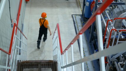 Safety engineer rushes accident site factory. Responding quickly emergency situation to ensure safety and mitigate damage. Wearing protective gear, prioritizing worker safety and emergency protocols.