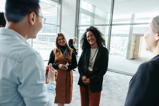 Colleagues networking at a corporate event in a modern office building