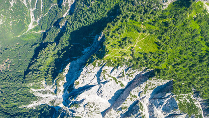 A stunning view of Slemenova Špica, showcasing a picturesque hiking trail in the Slovenian Alps. The image, captured from the air by a drone, highlights the breathtaking landscape, with rugged peaks 
