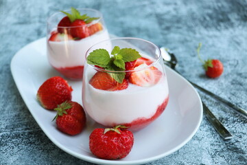 Red strawberries with whipped cream dessert on wooden background