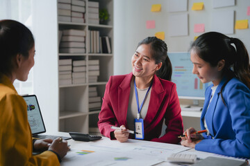 Team of asian businesswomen are having a meeting in an office, using a laptop and discussing financial documents