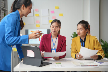 Fototapeta premium Three young businesswomen are analyzing financial data and discussing project strategy for their business