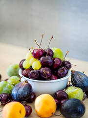 Fresh summer fruits in bowl with cherries, grapes, figs, apricot and greengages. Healthy dessert and snack. Vitamin rich breakfast with organic farm fruits.