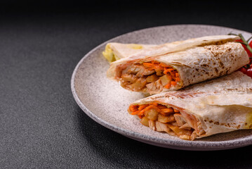 Delicious juicy roll or shawarma with chicken, tomatoes, salad and sauce
