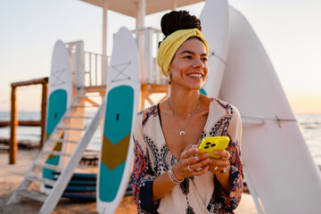smiling happy woman posing on beach with phone