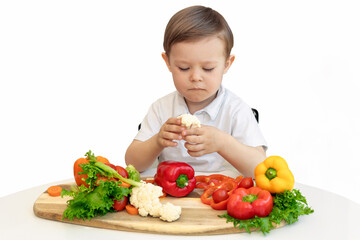 A little boy very unhappy with having to eat vegetables, isolate on white background