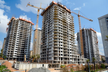 Construction Of High-Rise Residential Buildings Underway In A Busy Urban Area During Bright Daylight
