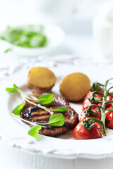 Grilled pork steak with vegetables. White wooden background. Close up. Copy space.