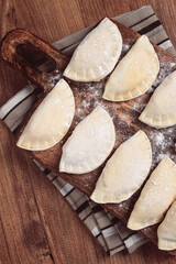 Traditional Polish dish, dumplings , raw, frozen, on a cutting board, wooden table, top view, no people,