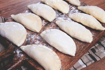 Traditional Polish dish, dumplings , raw, frozen, on a cutting board, wooden table, top view, no people,