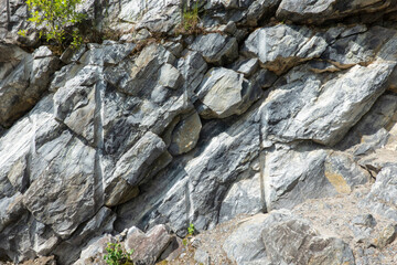 A fragment of a partially destroyed rock in a marble quarry. Individual stones and traces of...
