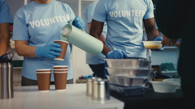 Multiethnic people volunteering at meal center, offering soup and hot drinks