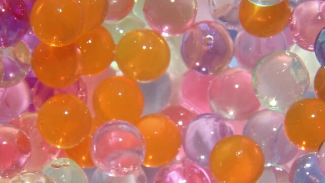 Tweezers are used to take one hydrogel earpiece at a time. Macro. Asmr. The multicolored orbis will be collected by spitz one at a time. Relaxing, soothing effect.